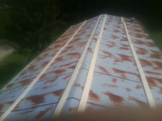 Rusted metal roof panels with new wood purlins before replacement — Storm Damage Roof Repair in New Church by Roofing Brothers