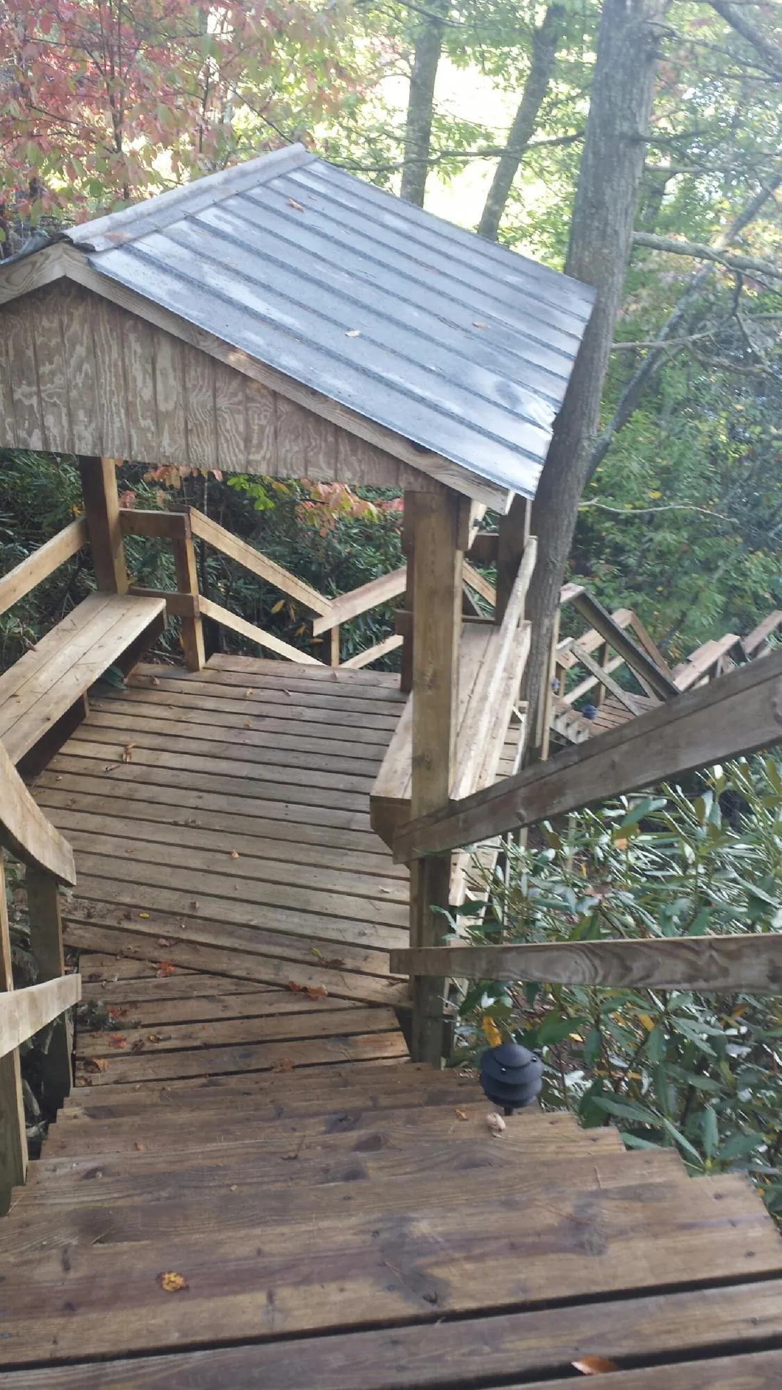 Metal roofed shelter over wooden steps on a wooded walkway — Skylight Repair & Installation work by our crew in New Church